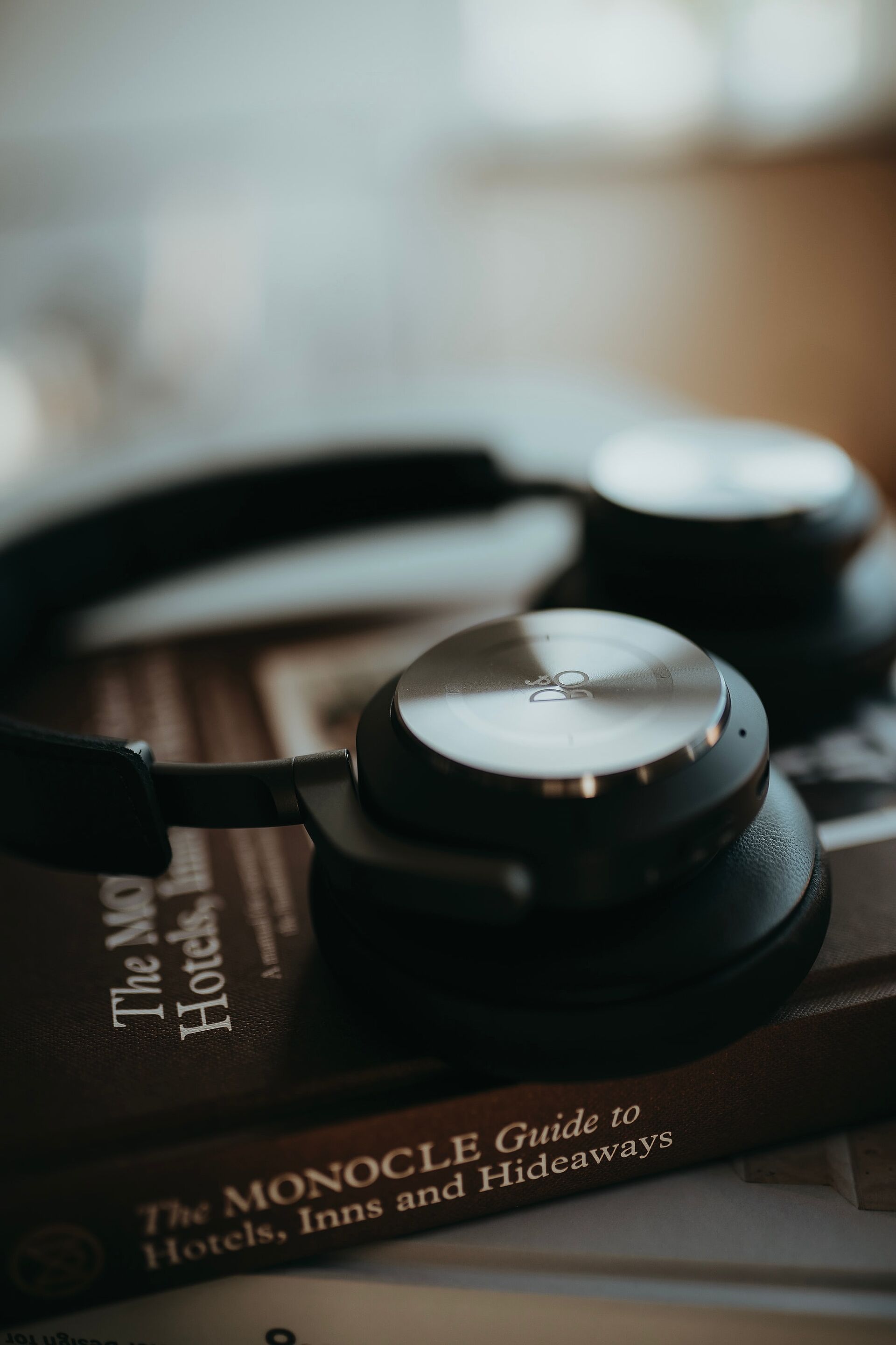 Nahaufnahme von schwarzen Over-Ear-Kopfhörern, die auf einem Buch liegen, mit weicher Tiefenunschärfe.